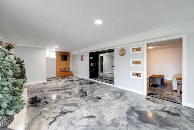 interior space featuring recessed lighting, baseboards, and concrete flooring