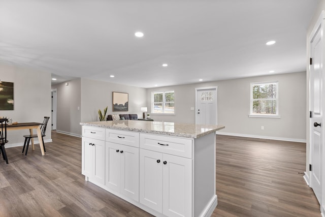 kitchen featuring recessed lighting, wood finished floors, a center island, and white cabinets