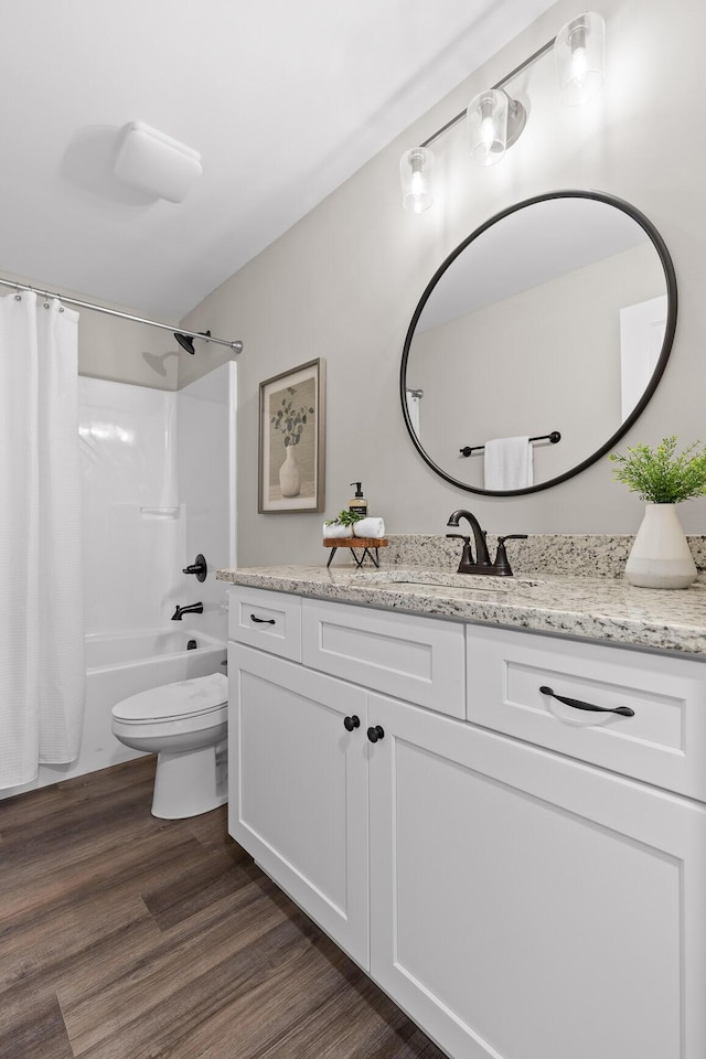 bathroom with vanity, toilet, wood finished floors, and shower / tub combo with curtain