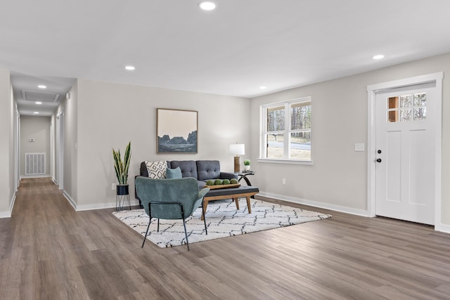 living area with visible vents, recessed lighting, and wood finished floors