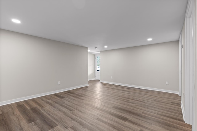 empty room featuring dark wood finished floors, recessed lighting, and baseboards