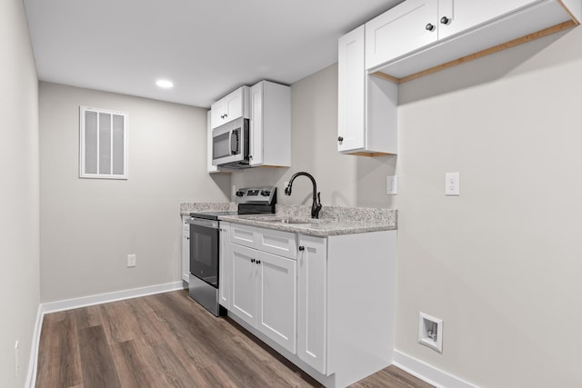 kitchen with a sink, visible vents, appliances with stainless steel finishes, and white cabinetry