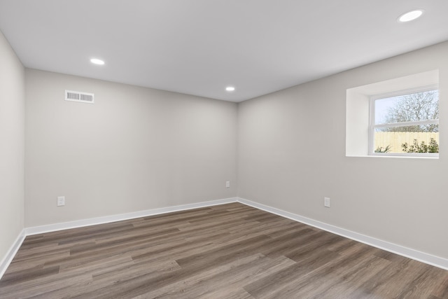 empty room featuring visible vents, recessed lighting, baseboards, and wood finished floors