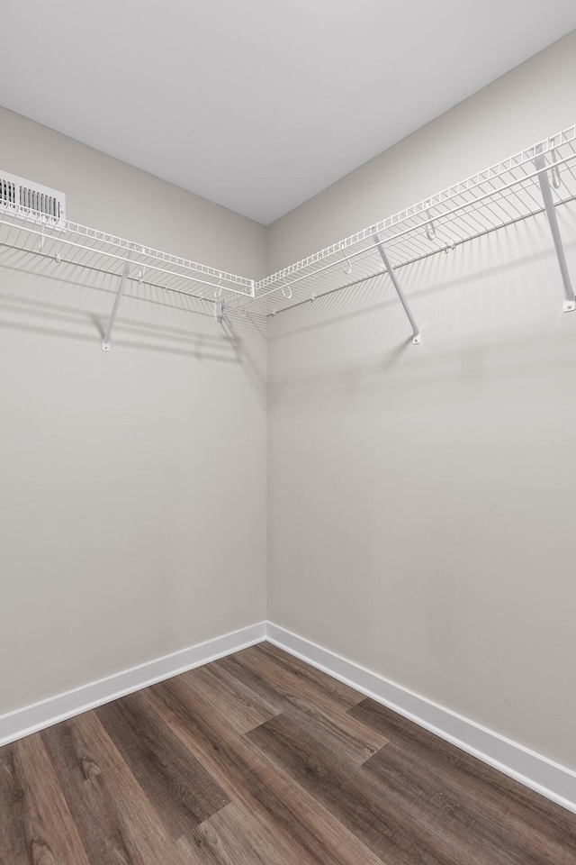 spacious closet with dark wood-type flooring and visible vents