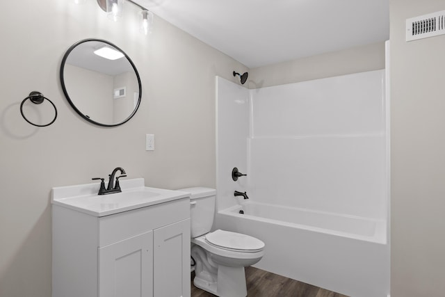 full bath featuring visible vents, toilet, wood finished floors, bathing tub / shower combination, and vanity