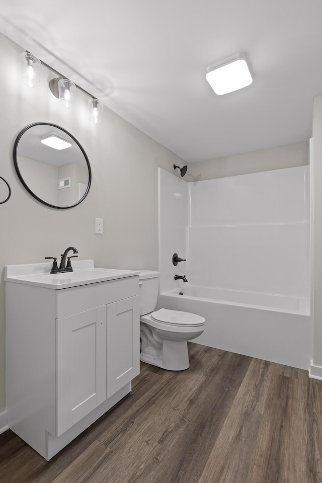 bathroom with vanity, wood finished floors, visible vents, bathtub / shower combination, and toilet