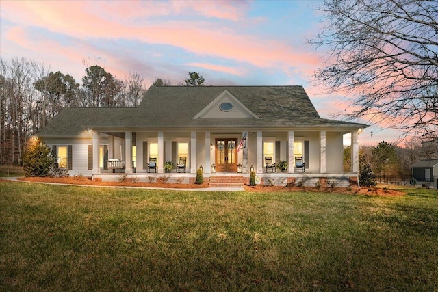 back of property with covered porch and a yard