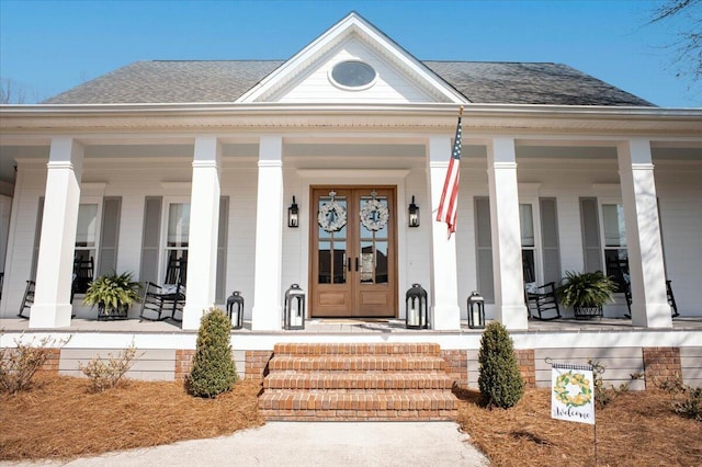 view of exterior entry with covered porch and french doors