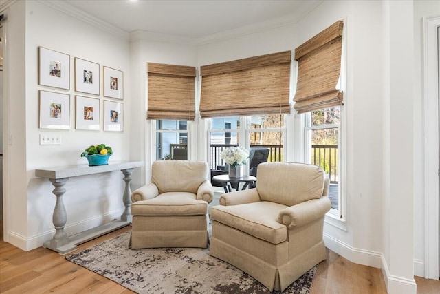 sitting room featuring crown molding, baseboards, and wood finished floors