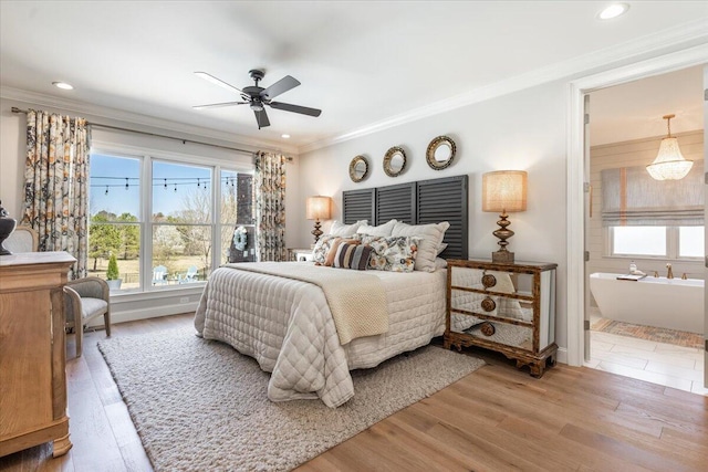 bedroom with crown molding, wood finished floors, and connected bathroom