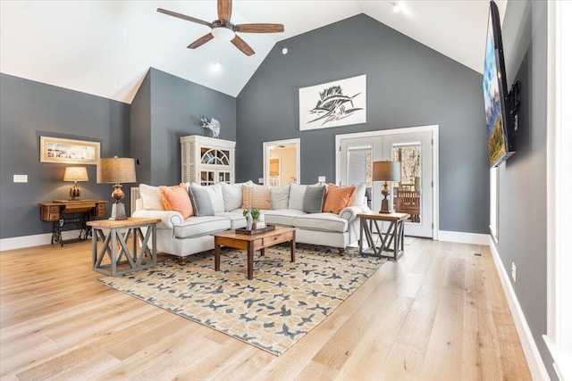 living room featuring baseboards, high vaulted ceiling, a ceiling fan, and wood finished floors