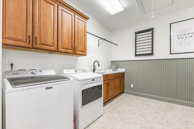 washroom with a wainscoted wall, attic access, cabinet space, a sink, and independent washer and dryer