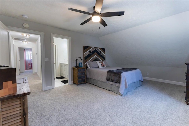 bedroom featuring a ceiling fan, baseboards, carpet floors, lofted ceiling, and ensuite bathroom