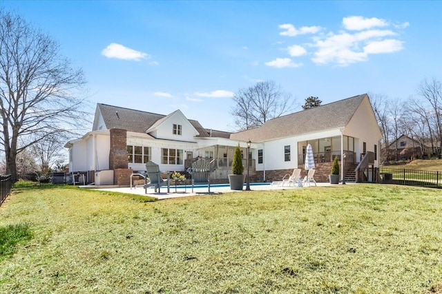 back of house with a patio area, a lawn, a fenced backyard, and a fenced in pool