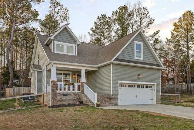 view of front of house featuring a front yard, fence, an attached garage, covered porch, and concrete driveway