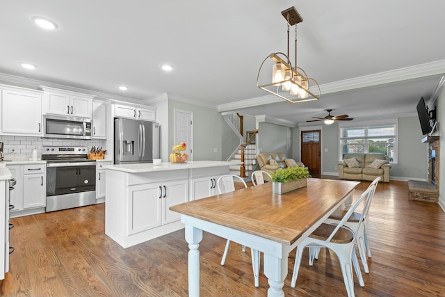 dining room featuring wood finished floors, stairway, a ceiling fan, and ornamental molding