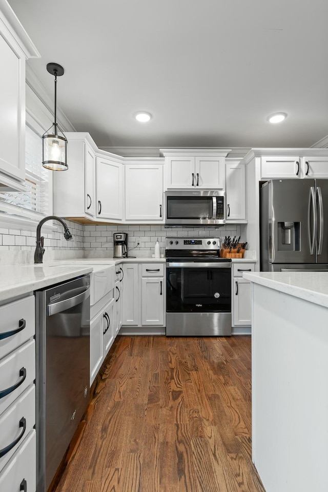 kitchen featuring decorative backsplash, dark wood-type flooring, appliances with stainless steel finishes, and white cabinetry