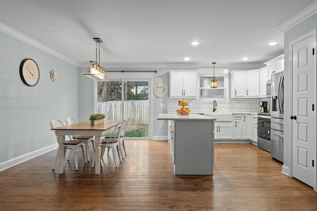 kitchen featuring white cabinetry, crown molding, and light countertops