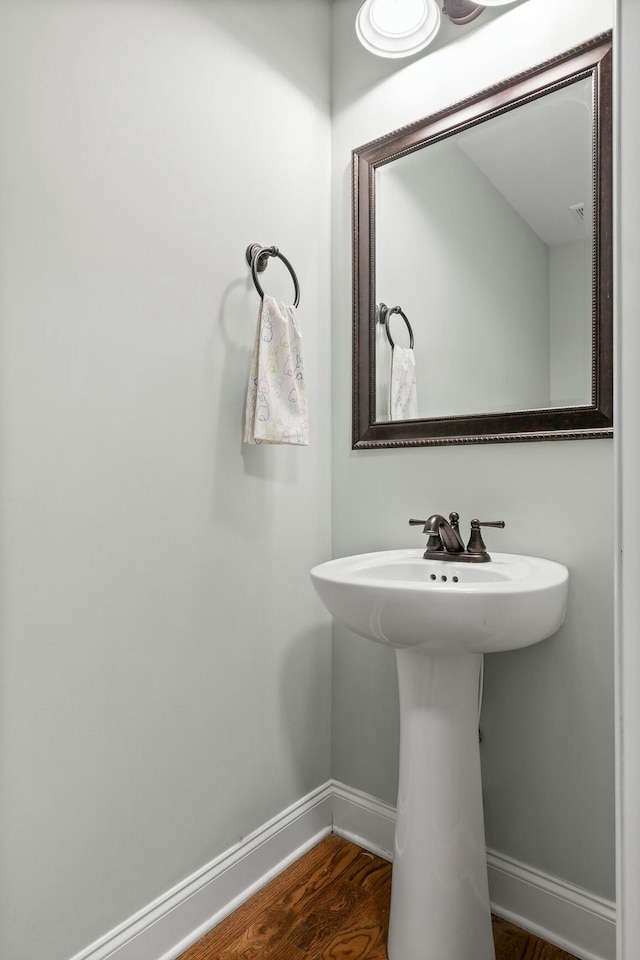 bathroom with baseboards and wood finished floors