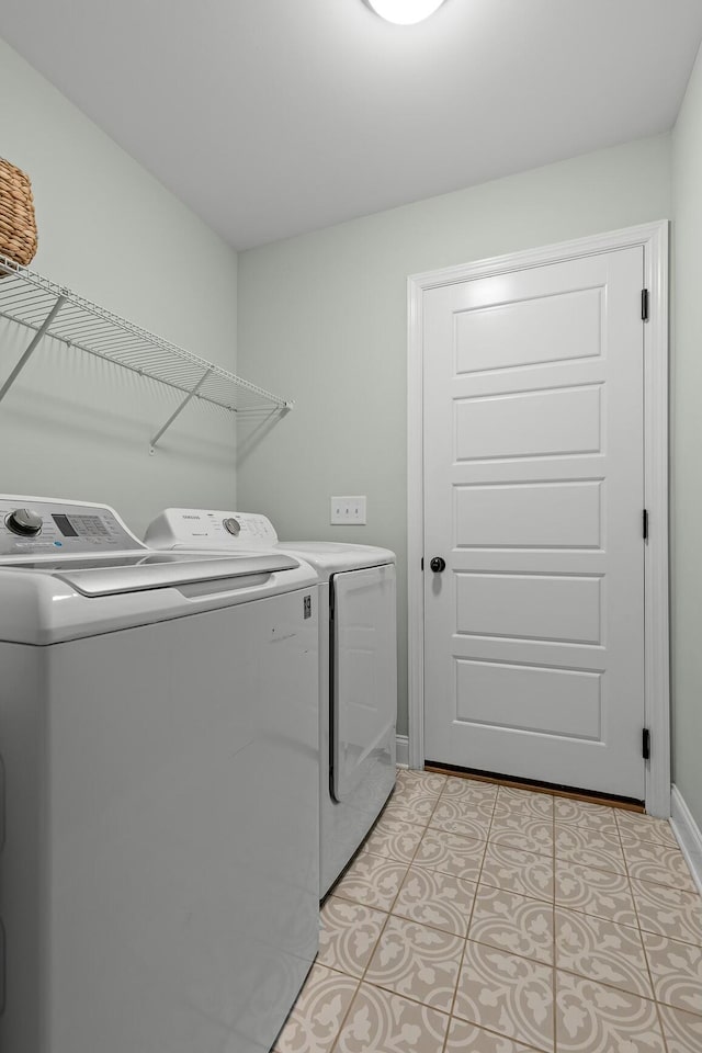 laundry room featuring light tile patterned floors, baseboards, washing machine and dryer, and laundry area