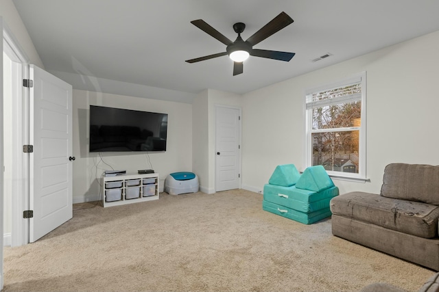 sitting room with baseboards, carpet, visible vents, and ceiling fan