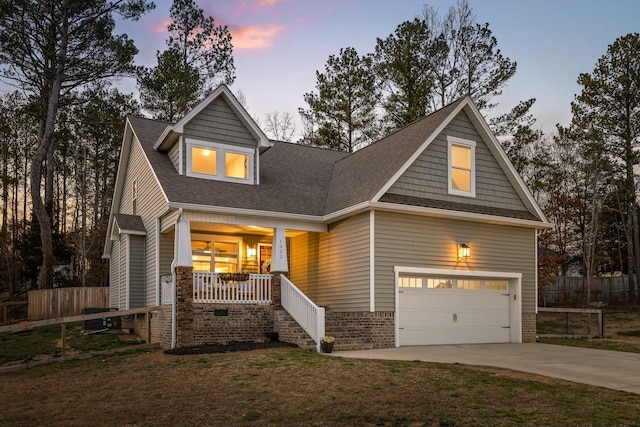 craftsman-style house featuring a lawn, driveway, a porch, fence, and a garage