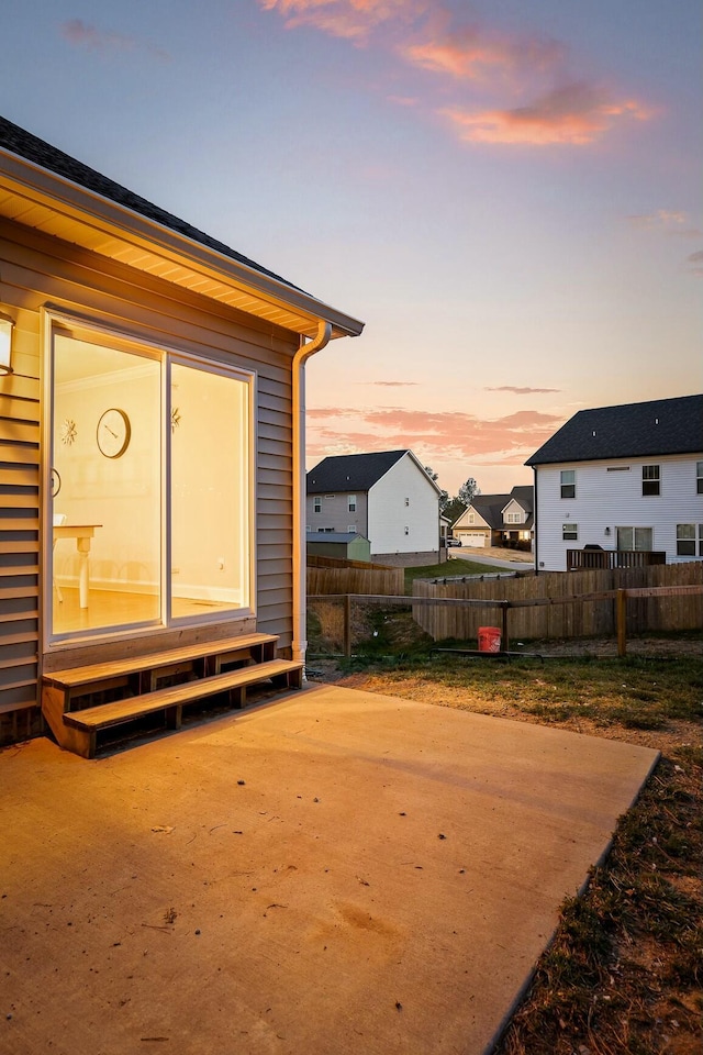 view of yard featuring entry steps, a patio, fence, and a residential view