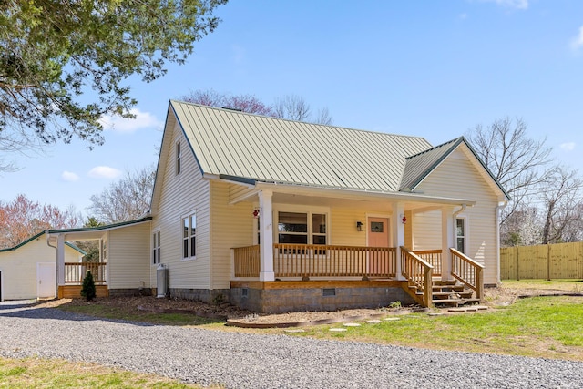 view of front of property featuring fence, a standing seam roof, a porch, crawl space, and metal roof