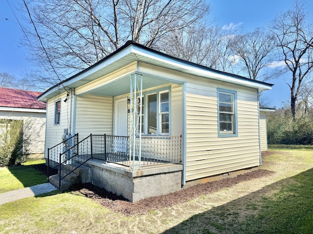 bungalow with covered porch and a front yard