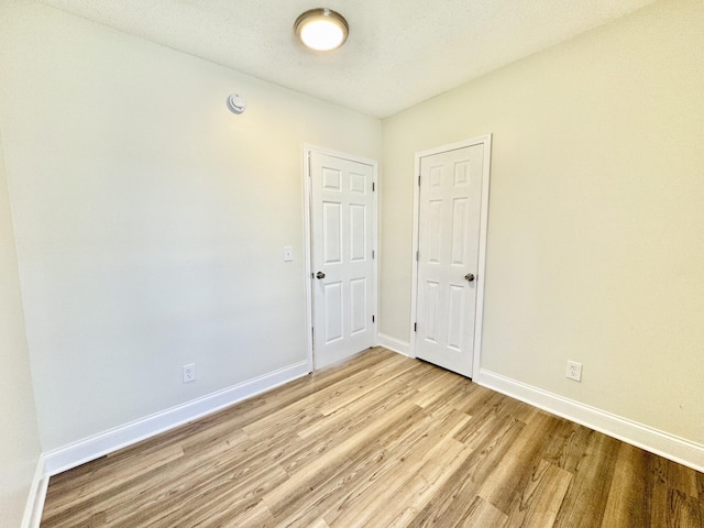 spare room with light wood-style flooring and baseboards