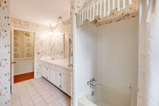 full bathroom with tile patterned flooring, wallpapered walls, wainscoting, bathing tub / shower combination, and vanity