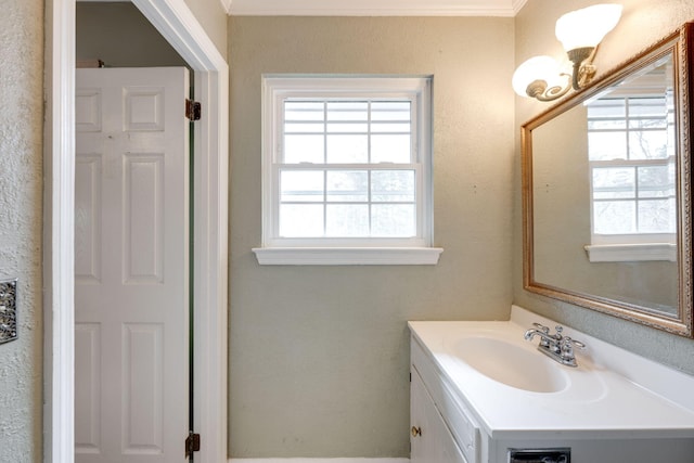 bathroom featuring plenty of natural light, vanity, and a textured wall