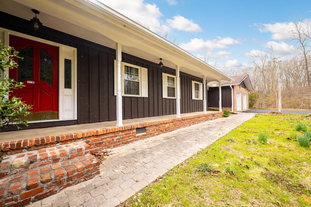 doorway to property featuring covered porch and board and batten siding