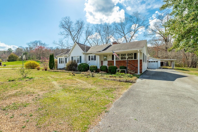 view of front of house with driveway, a garage, brick siding, a front lawn, and a porch