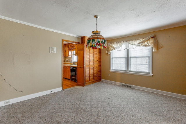 empty room featuring baseboards, a textured ceiling, visible vents, and crown molding