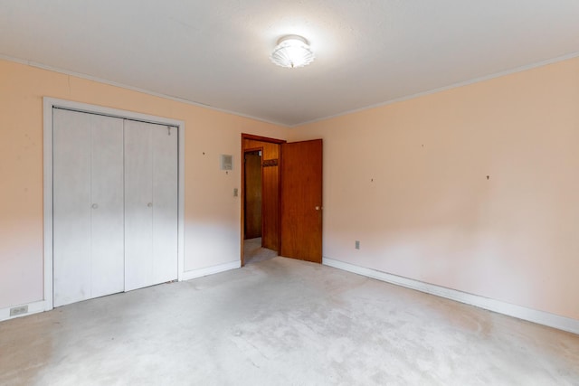 unfurnished bedroom with a closet, baseboards, and crown molding