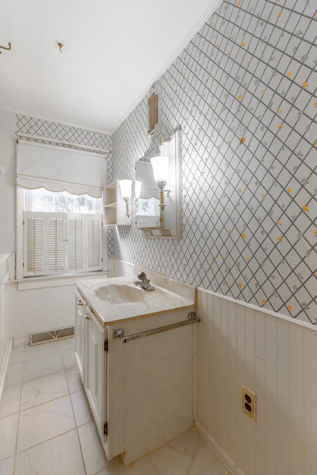 bathroom with marble finish floor, wallpapered walls, and vanity