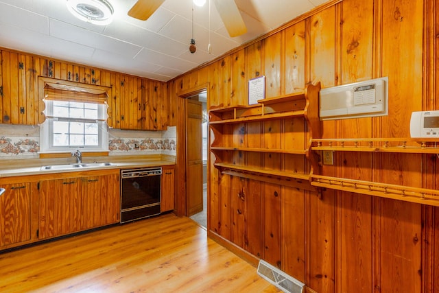 kitchen featuring visible vents, dishwasher, a sink, light wood-style floors, and brown cabinetry