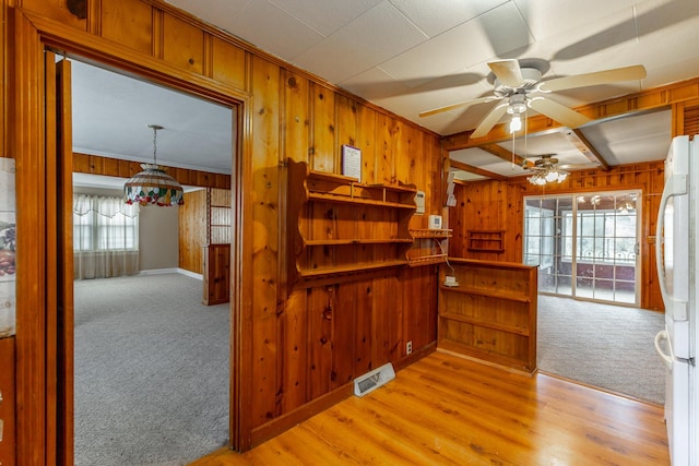 kitchen featuring carpet flooring, visible vents, freestanding refrigerator, ceiling fan, and wood finished floors