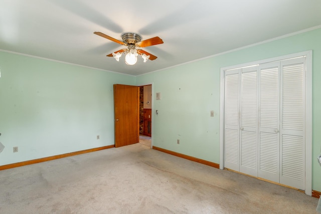 unfurnished bedroom with baseboards, crown molding, ceiling fan, and carpet flooring