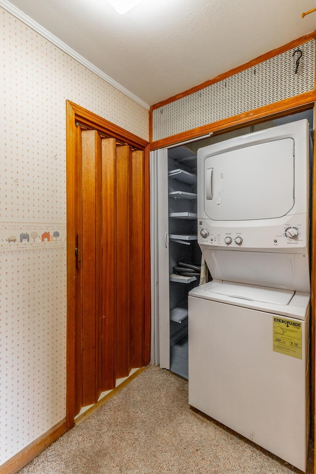 laundry room with crown molding, stacked washer / drying machine, laundry area, wallpapered walls, and light carpet