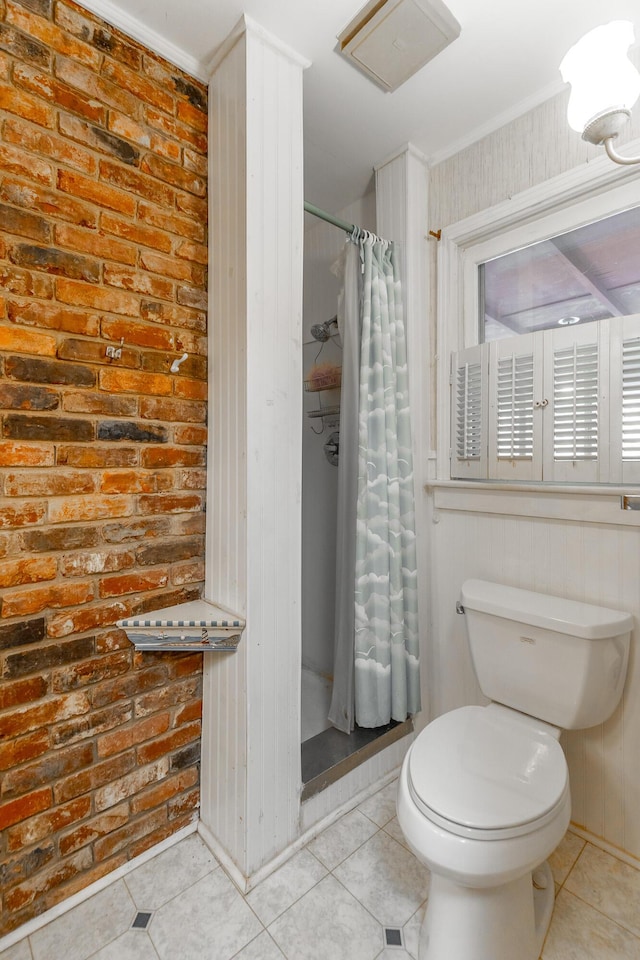 full bathroom featuring toilet, tile patterned flooring, a shower with shower curtain, and brick wall