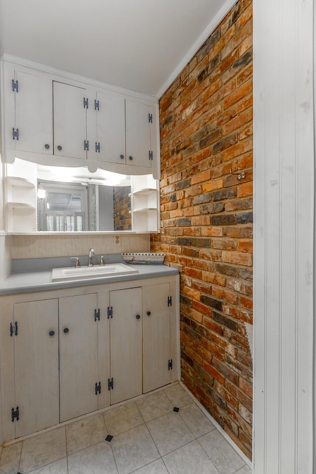 kitchen featuring light countertops, a sink, open shelves, brick wall, and light tile patterned floors