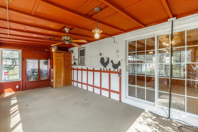 unfurnished sunroom featuring ceiling fan and beam ceiling