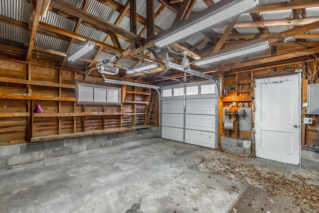 garage with a garage door opener and concrete block wall