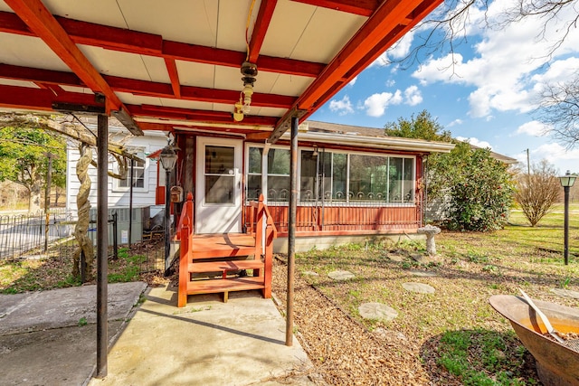 view of patio with a sunroom and fence