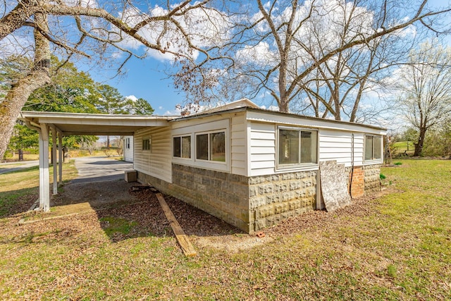 view of side of property with a lawn and a carport