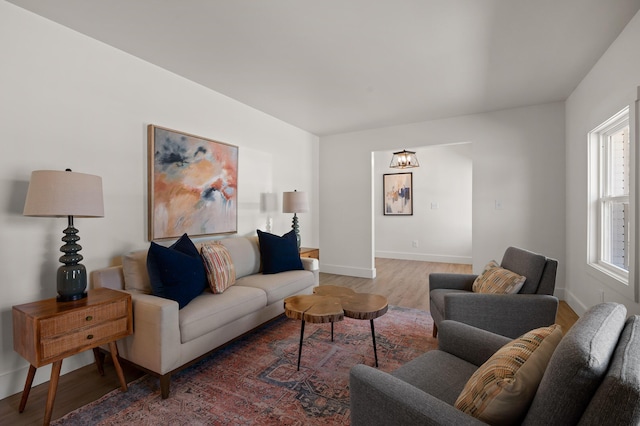 living area with baseboards and wood finished floors