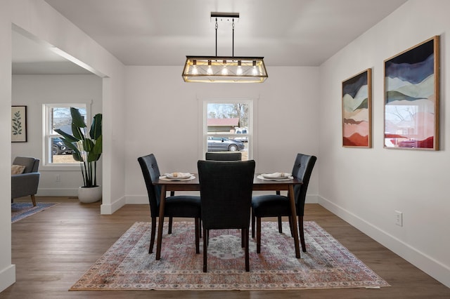 dining space featuring baseboards and wood finished floors