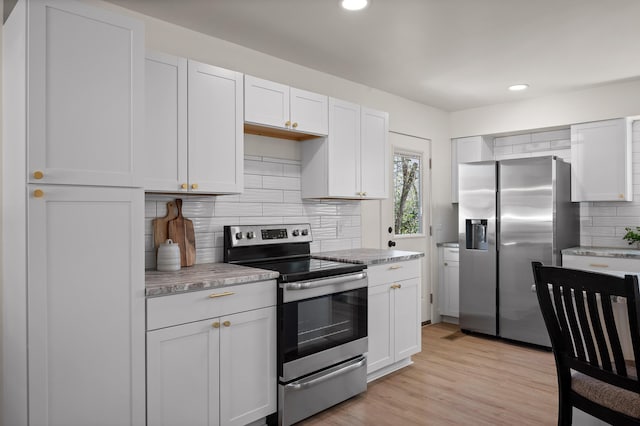 kitchen featuring decorative backsplash, light countertops, light wood finished floors, and stainless steel appliances